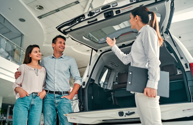 Comprando Su Primer Auto Juntos Vendedora De Automóviles Joven De Pie En El Concesionario 