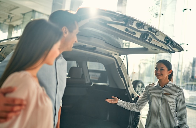 Comprando Su Primer Auto Juntos Vendedora De Automóviles Joven De Pie En El Concesionario 