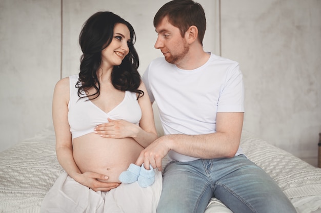 Concepto De Embarazo Y Personas Hombre Feliz Abrazando A Su Bella Esposa Embarazada En Casa Futuros Padres Esperando Bebe Nonato Foto Premium