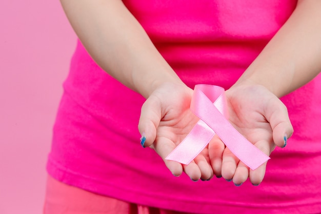 Conciencia del cáncer de mama cinta rosa colocada en ambas manos es un