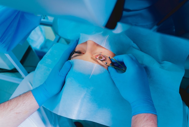Corrección de la visión con láser un paciente y un equipo de cirujanos en el quirófano durante