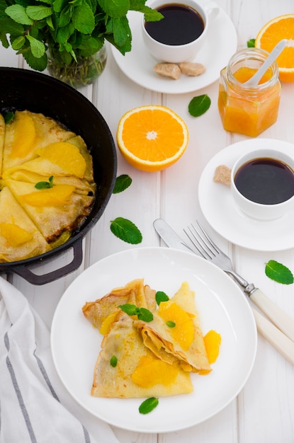 Crepe Suzette Con Salsa De Naranja Y Una Taza De Café Desayuno Sabroso Y Fragante Foto Premium