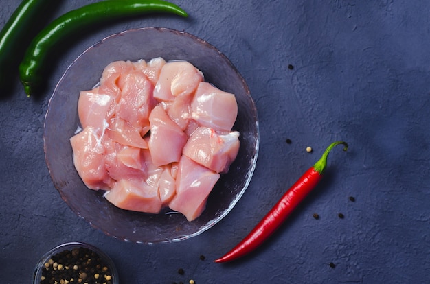 Cubitos De Pollo Crudo En Un Tazón Y Chiles Foto Premium