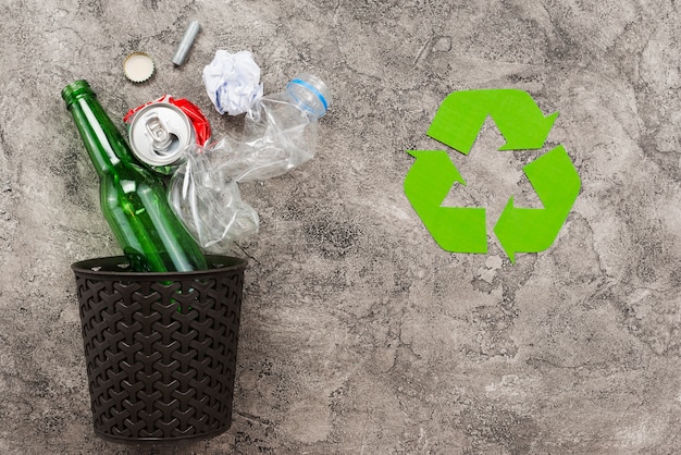 Cubo de basura con basura junto a reciclaje de logo Foto gratis