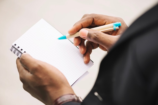 Cultivo hombre escribiendo en cuaderno en blanco | Foto Gratis