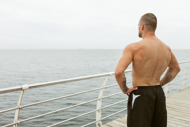 Culturista Masculino Musculoso Con El Torso Desnudo Posando En La Playa