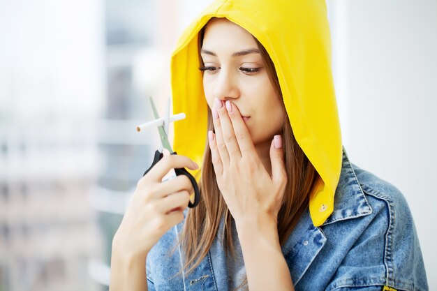 Deje de fumar, una mujer joven rompe un cigarrillo instando a dejar de fumar Foto Premium 