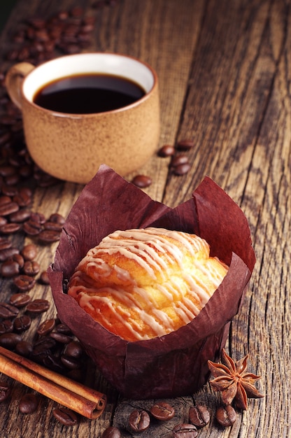 Delicioso muffin y taza de café en la mesa de madera vintage | Foto Premium