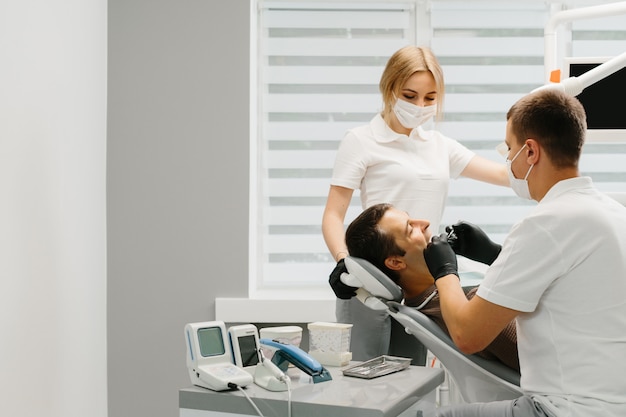 Dentista Con Un Asistente De Trabajo En Una Clinica Dental Foto Premium