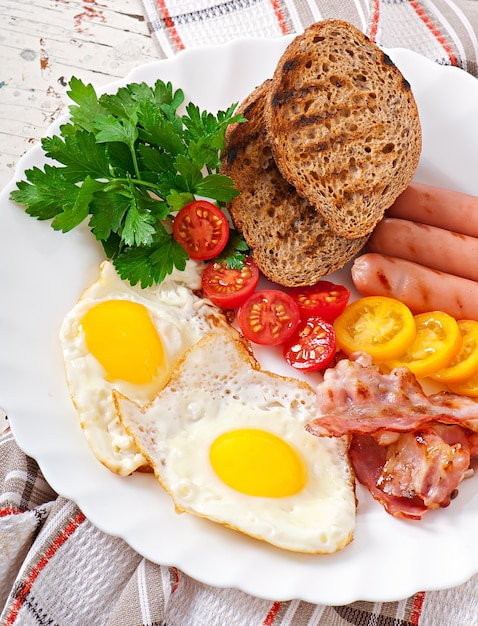 Desayuno Ingles Huevos Fritos Tocino Salchichas Y Pan De Centeno Tostado Foto Gratis