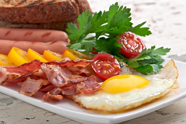 Desayuno Ingles Huevos Fritos Tocino Salchichas Y Pan De Centeno Tostado Foto Premium