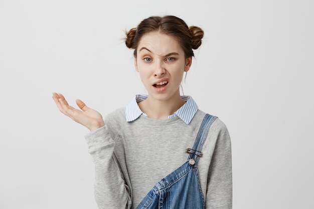 Disparos En La Cabeza De La Alegre Chica Torciendo Los Labios Persona Publica De Moda Femenina Mirando Esceptico Vomitando Mano Demostrando Algun Producto Copia Espacio Comercial Foto Gratis