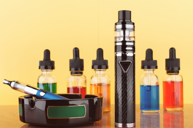 Dispositivos de vapeo y botellas con vape líquido sobre ...