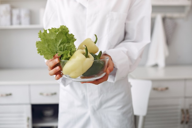 Doctor en una cocina con verduras Foto gratis