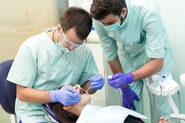 Doctor Dentista Con Un Asistente De Trabajo En Una Clinica Dental Foto Premium