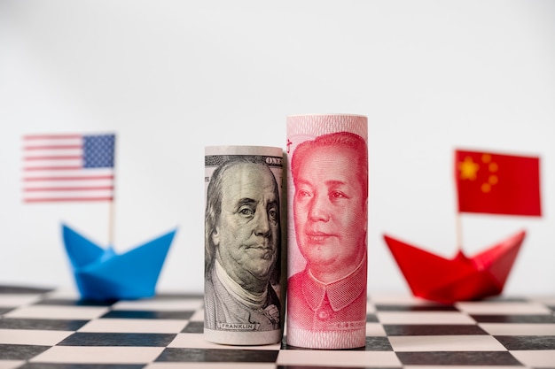 DÃ³lar de amÃ©rica y el billete de yuan en el tablero de ajedrez con banderas de estados unidos y china. Foto Premium 