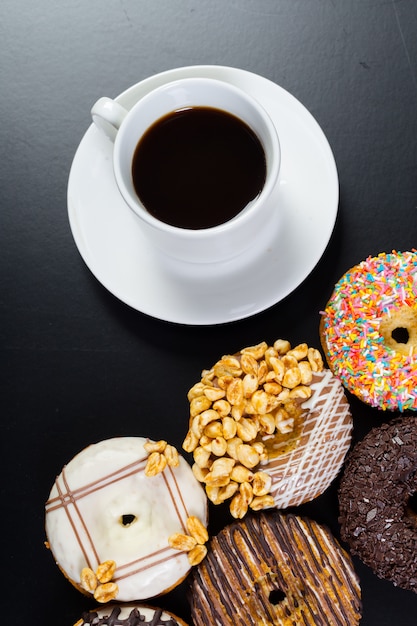 Donut y café en el fondo negro Foto Premium