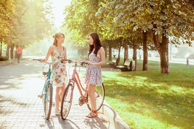 Las Dos Chicas Jóvenes Con Bicicletas En El Parque Foto Gratis