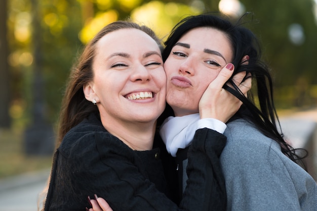 Dos Chicas Morenas Caucásicas Se Abrazan En El Soleado Parque De Otoño Feliz Pareja De 