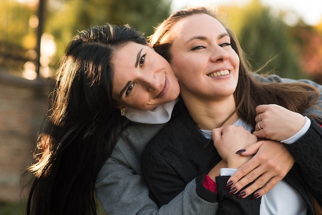 Dos Chicas Morenas Caucásicas Se Abrazan En El Soleado Parque De Otoño Feliz Pareja De 3310