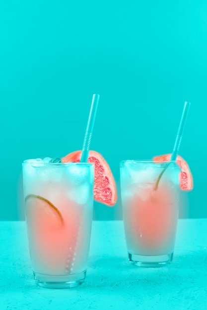 Dos copas de refresco de pomelo cóctel sobre fondo de menta Foto gratis