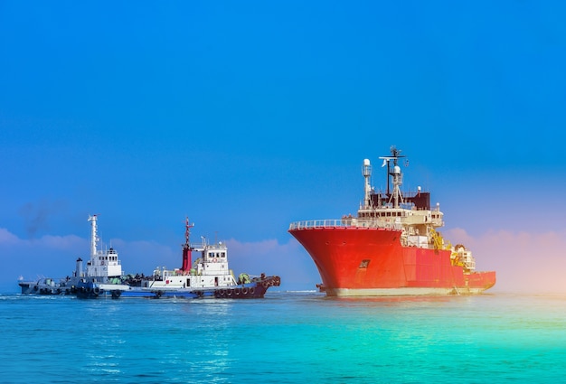 Dos Remolcadores De Asistencia En Bote Con Remolcador Grande Al Dique Seco Flotante En El Mar Foto Premium