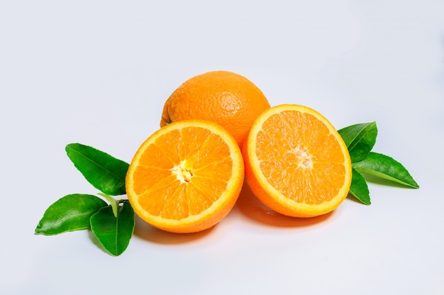 Dos Rodajas De Naranja Fresca Y Una Fruta Naranja Con Hojas Verdes