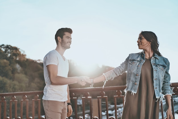 Ella Es La Indicada Para él Hermosa Joven Pareja Cogidos De La Mano Y Sonriendo Foto Premium 