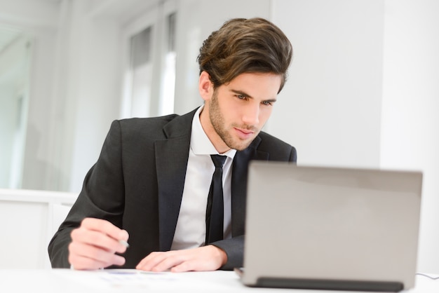 Empleado joven trabajando en su informe | Foto Gratis