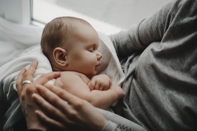 Encantador Nino Recien Nacido Duerme En Los Brazos De La Madre Foto Gratis