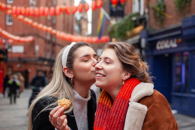 Encantadoras mujeres lesbianas besándose al aire libre Foto Gratis