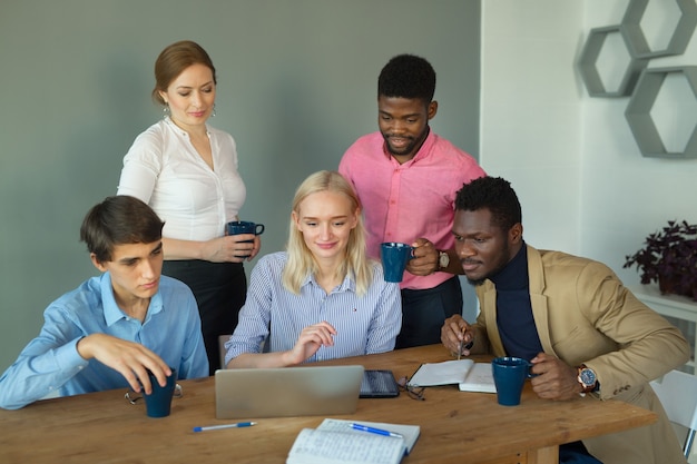 Equipo de gente joven hermosa en la oficina en la mesa con ...