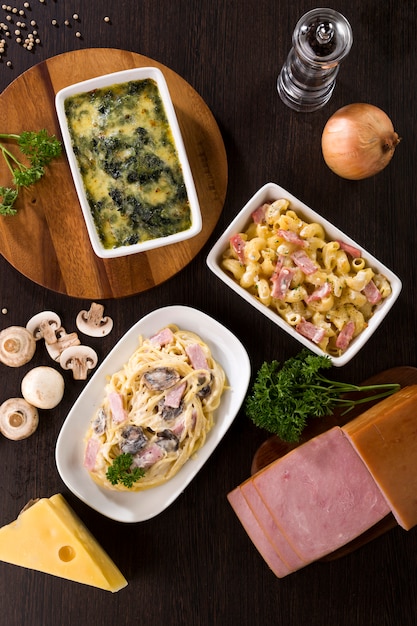 Espaguetis a la carbonara, jamón de macarrones con queso y espinacas al horno con queso Foto Premium