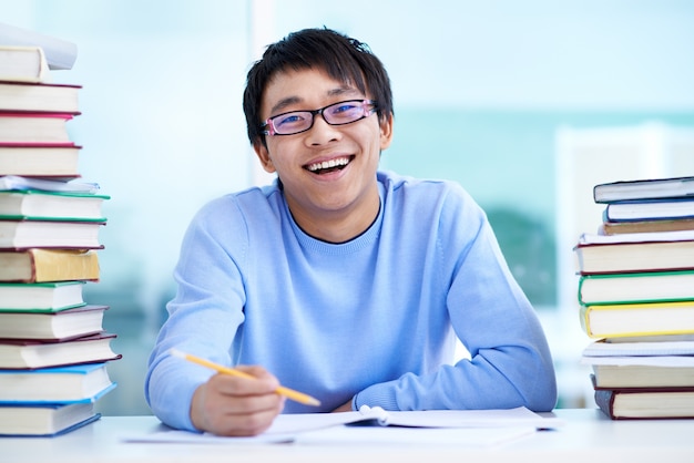 Estudiante Sentado En El Escritorio Con Libros Sobre La Mesa