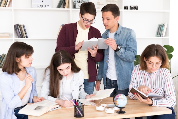 Estudiantes trabajando juntos en la biblioteca | Foto Gratis