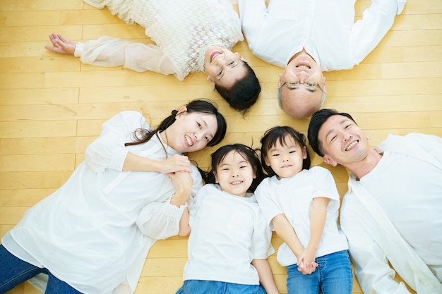 Familia de 3 generaciones tendida en el suelo de la habitación Foto