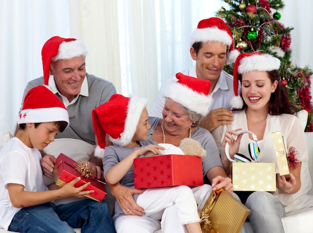 Familia Abriendo Regalos De Navidad En Casa | Foto Premium