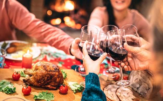 Familia Brindando Vino Tinto Y Divirtiéndose En La Cena De Navidad Foto Premium 