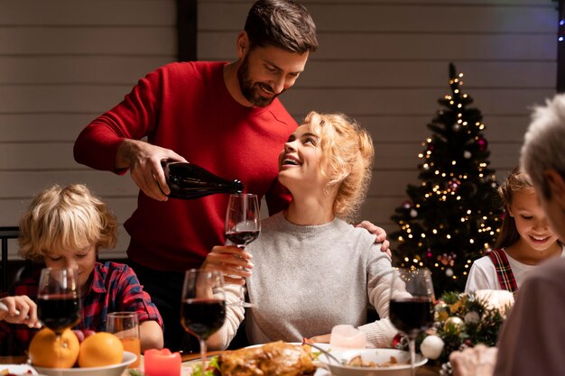 Familia celebrando en una cena navideña festiva Foto gratis