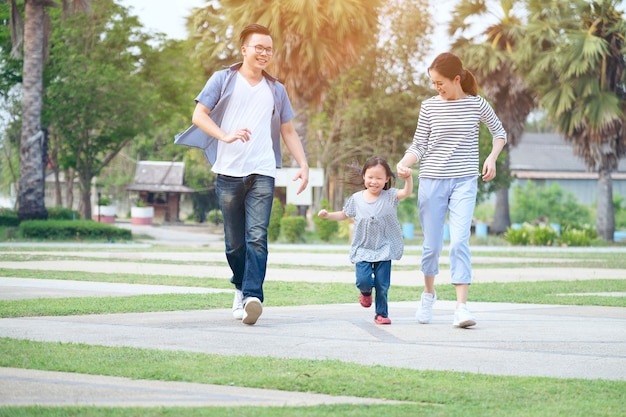 Familia corriendo por el jardín en el parque, familia feliz en el parque,  madre, padre | Foto Premium