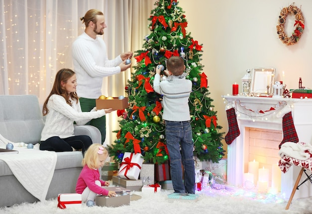 Familia Decorar El árbol De Navidad En La Sala De Estar De Vacaciones ...