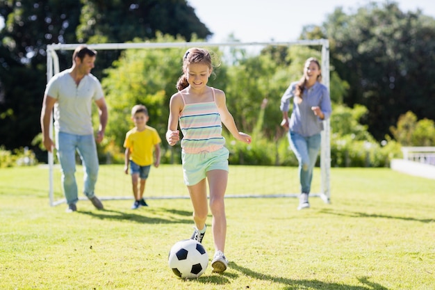 Familia feliz jugando al fútbol en el parque Foto Premium