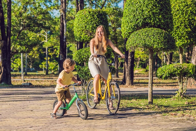 La Familia Feliz Está Montando En Bicicleta Al Aire Libre Y Sonriendo Mamá En Bicicleta E Hijo 1067