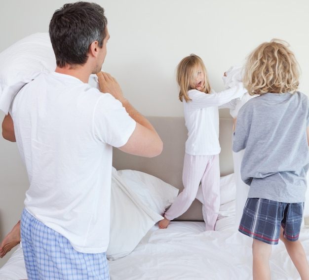 Familia Juguetona Teniendo Una Pelea De Almohadas Foto Premium