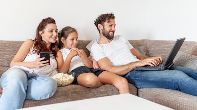 Familia Mirando Juntos En La Computadora Portatil Foto Gratis