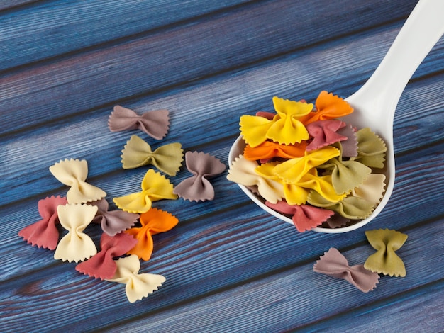 Farfalle de pasta italiana colorida seca o arcos con cuchara sobre ...