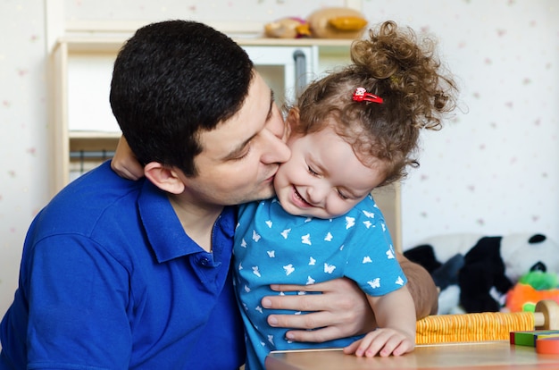 Feliz Dia Del Padre Papa E Hija Divirtiendose Y Jugando En Casa Los Padres Besan A Su Bebe Foto Premium