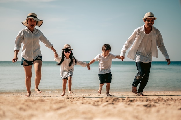 Feliz familia asiática los padres están tomados de la mano de sus hijos