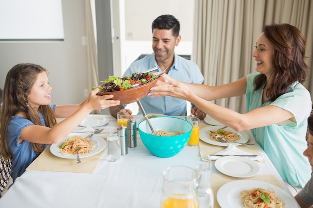 Feliz Familia De Tres Sentados En La Mesa De Comedor | Foto Premium