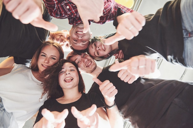 Feliz grupo de amigos con las manos juntas en el medio Foto gratis